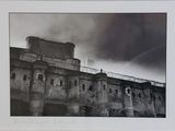 a black and white photo of a building on a cloudy day