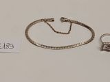 un bracelet et une bague en argent, accompagnés d'une chaîne, sur un fond blanc