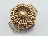 a close up of a gold buckle on a white surface