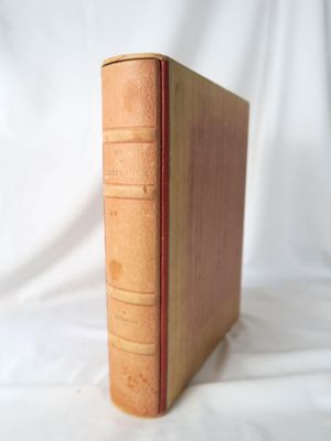 un vieux livre posé sur une table recouverte d'un tissu blanc