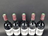 six bottles of wine are lined up in a row on a table