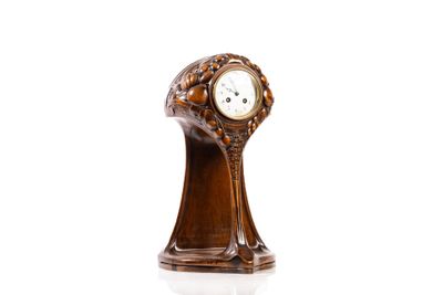 une horloge en bois posée sur une surface blanche