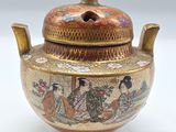 un petit vase muni d'un couvercle orné d'une peinture