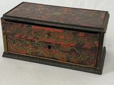 une vieille boîte en bois ornée d'un motif rouge et noir