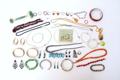 many different types of jewelry laid out on a white surface