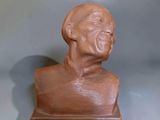 a clay bust of a man sitting on a table