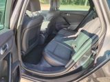 the back seats of a car with the door open and the driver ' s seat folded down