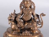 statue en laiton représentant une femme assise sur un lion, tenant un pot