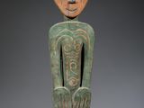 une statue en bois d'un homme avec un chapeau sur la tête