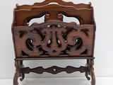 a wooden magazine rack with a carved design on it
