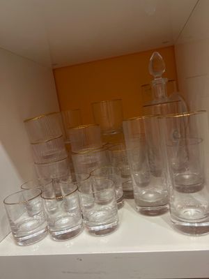 Des bouteilles et des verres sont alignés sur une étagère dans une pièce