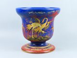 un vase bleu orné d'un motif doré et rouge