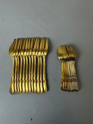 deux couverts en argent plaqué or posés sur une table