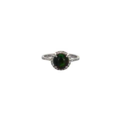 a close up of a ring with a green stone in it