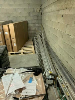 une valise posée par terre à côté d'une pile de cartons