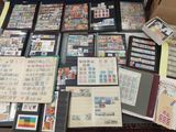 beaucoup de timbres posés sur une table, à côté d'un ordinateur portable