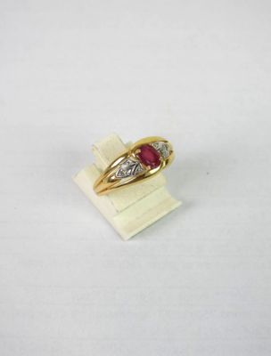 gros plan d'une bague en or avec une pierre en rubis
