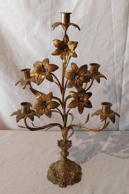 un bougeoir en laiton orné de fleurs, posé sur une table