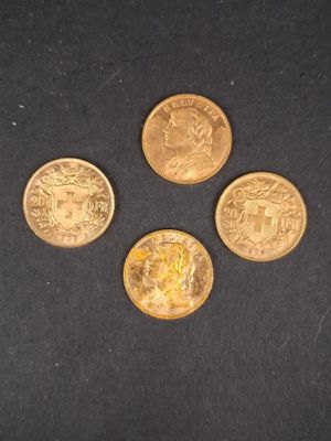 quatre types différents de pièces d'or sur une surface noire