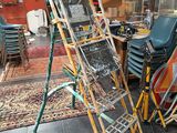 une échelle posée dans une pièce où se trouvent de nombreuses chaises