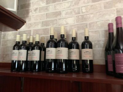 Des bouteilles de vin sont alignées sur une étagère devant un mur de briques