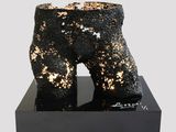 black and gold sculpture of a pair of boots on a black base