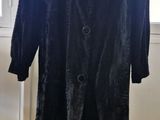 une image d'un manteau noir sur un support de mannequin