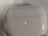 a white airpods with a red dot in the middle of it