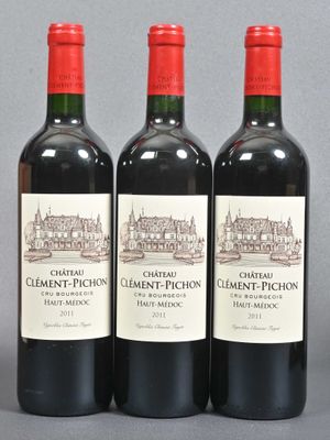 three bottles of red wine sitting next to each other on a table