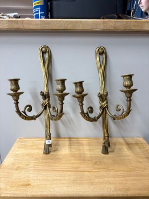 trois chandeliers en laiton posés sur une table en bois dans une pièce