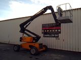 a picture of a man on a cherry picker in front of a building