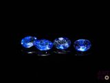 a close up of a group of blue gems on a black surface