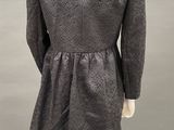 the back of a woman ' s dress with a collared neckline and long sleeves