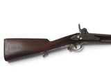 un vieux fusil avec un canon en bois et des garnitures en laiton