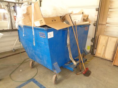 a blue dumpster with a cardboard box on top of it