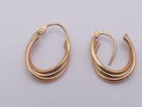 a pair of gold hoop earrings on a white background