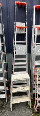 four ladders sitting next to each other in front of a building