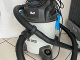 un aspirateur posé par terre à côté d'un radiateur