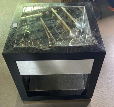 une table en verre avec un plateau en verre, posée sur un sol recouvert de moquette