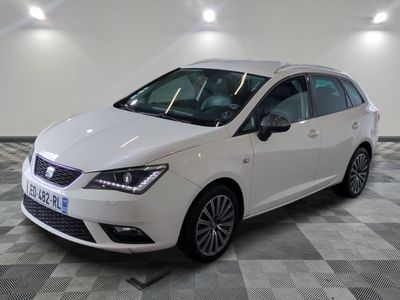 la voiture blanche est garée sur un sol en damier dans le garage