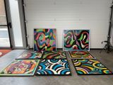 three large paintings are sitting on the floor in front of a window