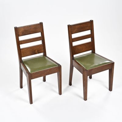une paire de chaises en bois avec des assises en cuir vert sur fond blanc