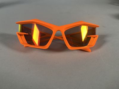 an orange pair of sunglasses with reflective lenses on a table
