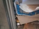 a pile of papers sitting on the floor in the corner of the room