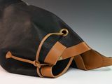 a black bag with a brown strap on it