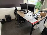 un bureau sur lequel sont posés deux écrans et un ordinateur portable