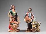 two figurines of a man and a woman with baskets of food