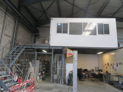 une photo d'un bâtiment avec un escalier et une mezzanine au-dessus