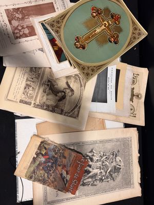 beaucoup de vieux livres posés sur une table sur laquelle est dessinée une croix