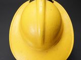 a yellow fireman ' s hat on a black background